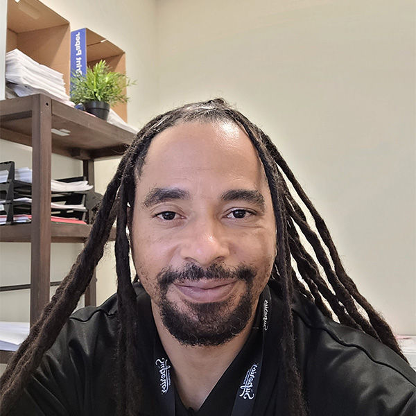 A man with dreadlocks taking a selfie