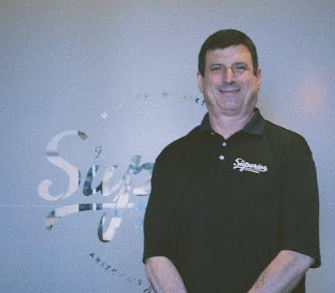 Robert Aronin A man wearing a superior dispensary shirt posing for a photo