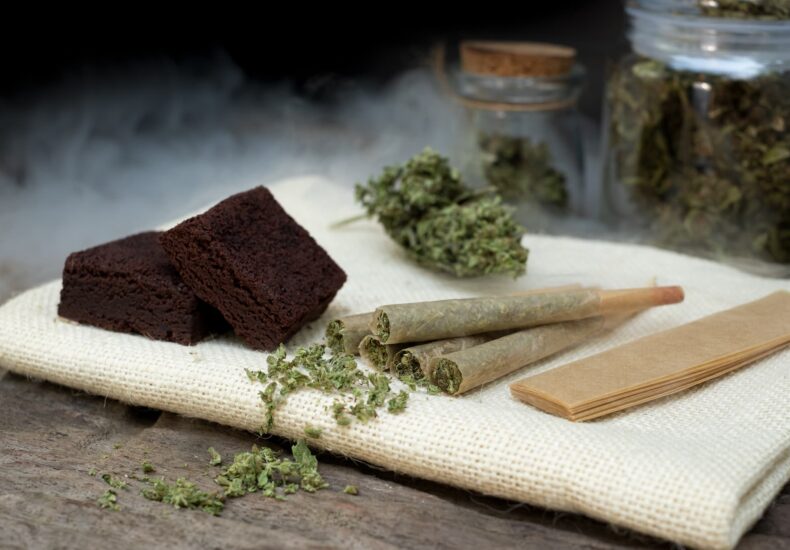Five Cannabis Pre rolls Next to Rolling Papers